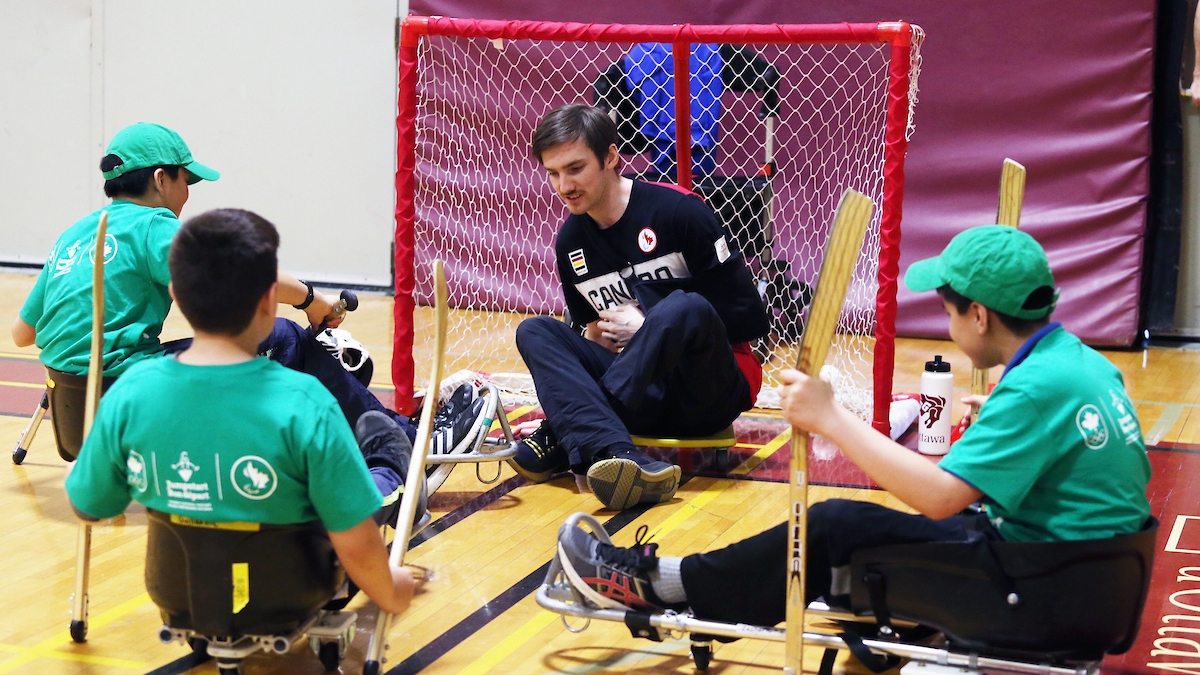 Rob Armstrong and a group of kids try an adapted version of Para ice hockey at a Canadian Tire Jumpstart event in 2018