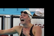 Stephanie in the pool after a race with a delighted look on her face after realizing she reached the podium