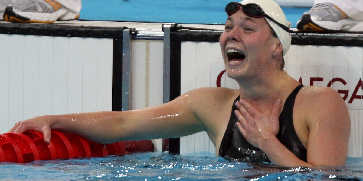 Stephanie in the pool after a race with a delighted look on her face after realizing she reached the podium