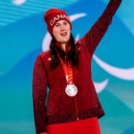 Lisa DeJong celebrates on the podium with her silver medal at the Beijing 2022 Winter Paralympics.