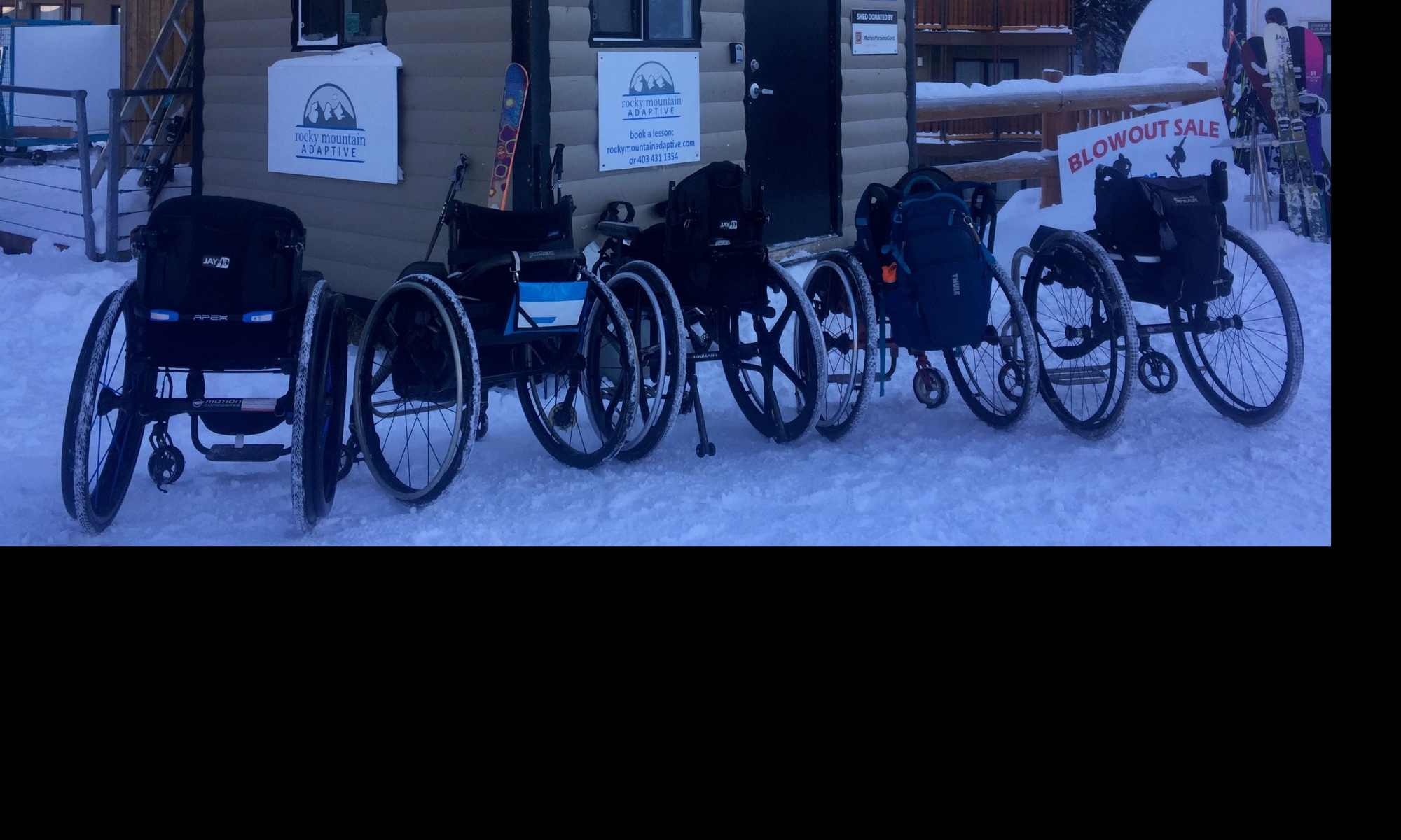 Wheelchairs in front of a skiing shed