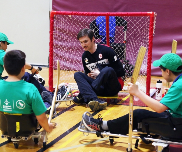 Rob Armstrong and a group of kids try an adapted version of Para ice hockey at a Canadian Tire Jumpstart event in 2018