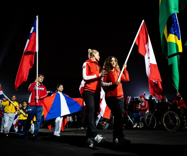 Carla Shibley and pilot Meghan Lemiski carry the flag at the Lima 2019 Closing Ceremony.