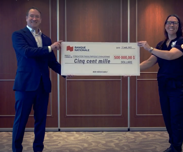 Louis Vachon, president and CEO of National Bank, and Paralympian Karolina Wisniewska hold up a $500,000 cheque in support of the Paralympic Foundation of Canada.