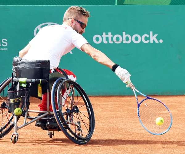 Rob Shaw reached from his chair low to ground for tennis ball