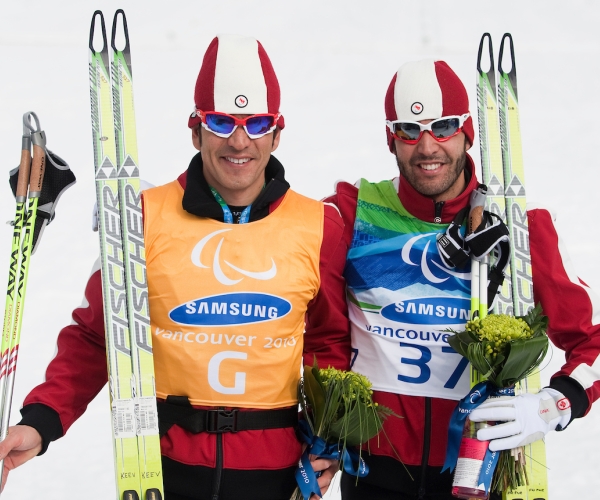 Brian McKeever (right) and Robin McKeever (left) standing and smiling together after competing at the Vancouver 2010 Paralympic Winter Games