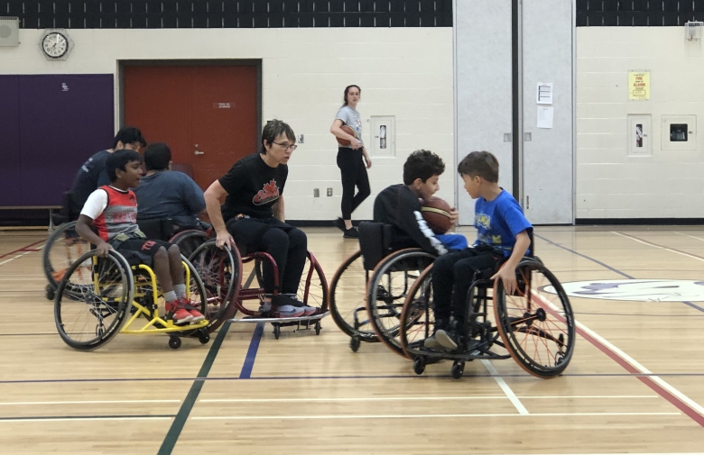 A group of youth participating in wheelchair basketball at Cruisers Sports