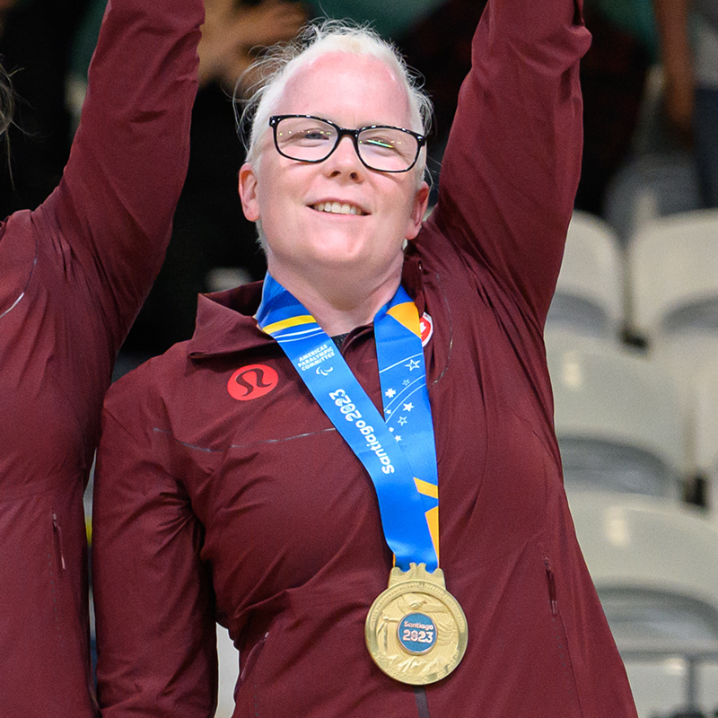 Whitney Bogart wearing a gold medal on the podium of the Santiago 2023 Parapan American Games.