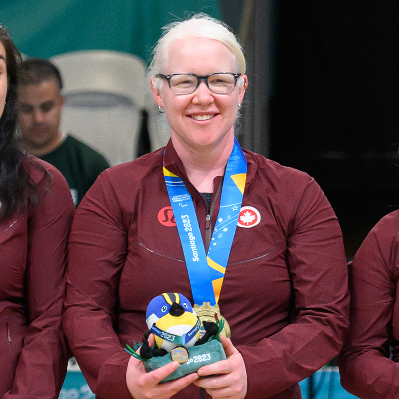 Canadian Goalball captain poses with her gold medal on the podium at the Santiago 2023 Parapan American Games.