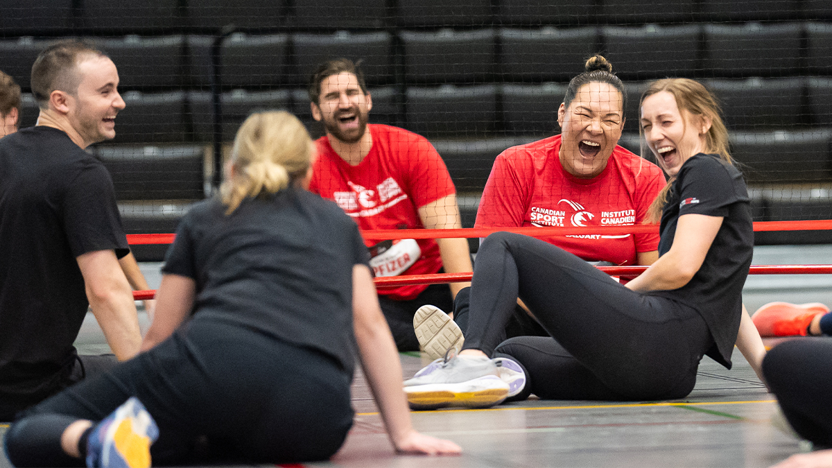 Participants enjoying the ParaTough Cup event in Calgary. | Des participants rient en jouant au volley-ball assis lors de la ParaTough Cup à Calgary.