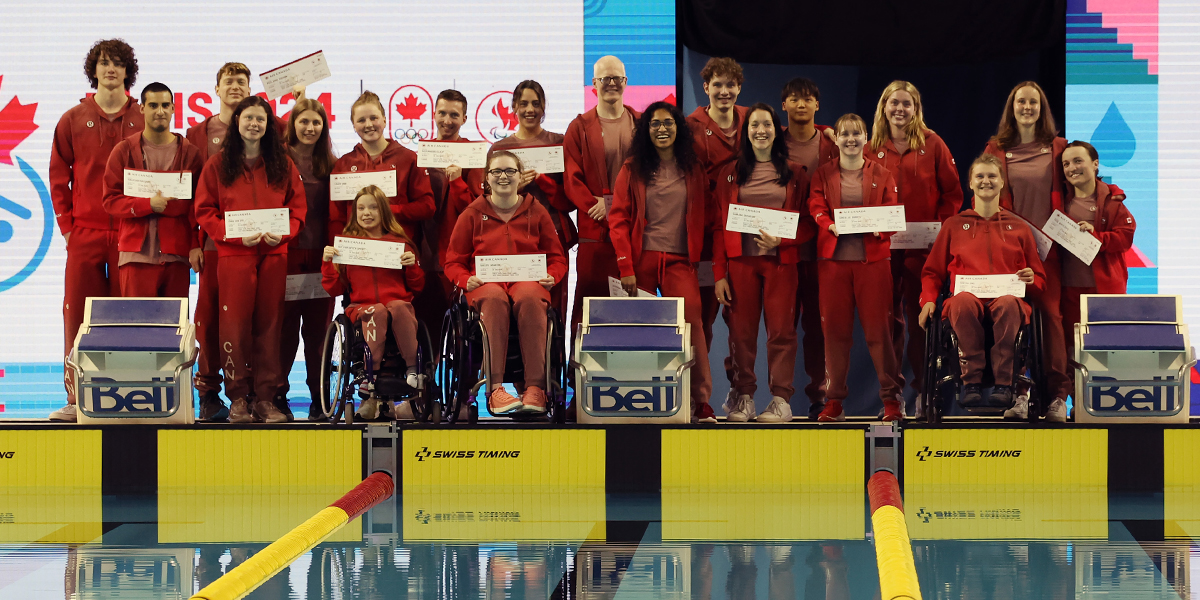 Photo of the Canadian Para swimmers nominated for the Paris 2024 Paralympics together on a pool deck all wearing the Canadian Paralympic Team jacket. | Photo des nageurs paralympiques canadiens nominés pour les Jeux paralympiques de Paris 2024 ensemble sur le bord d'une piscine, tous portant la veste de l'équipe paralympique canadienne.