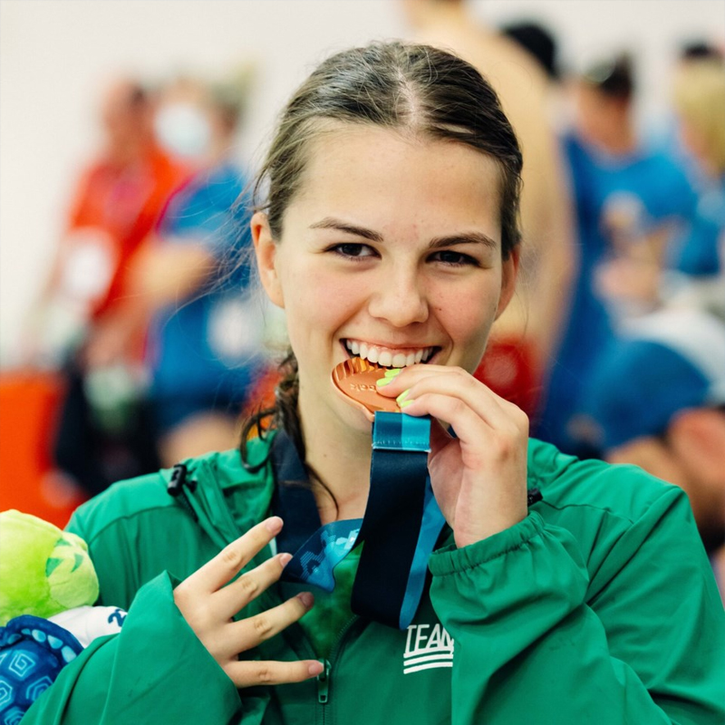 La nageuse paralympique canadienne Hannah Ouellette célèbre après une course en mordant sa médaille.