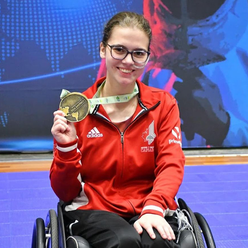 L'escrimeuse en fauteuil roulant canadienne Trinity Lowthian célèbre avec sa médaille d'or aux Championnats américains de 2024.