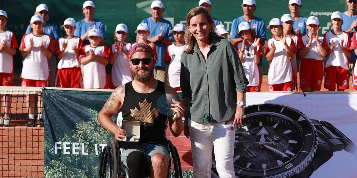 La star canadienne du tennis en fauteuil roulant Rob Shaw pose avec son trophée de vainqueur à l’Open de Suisse 2024, debout à côté de Rob est un officiel du tournoi.