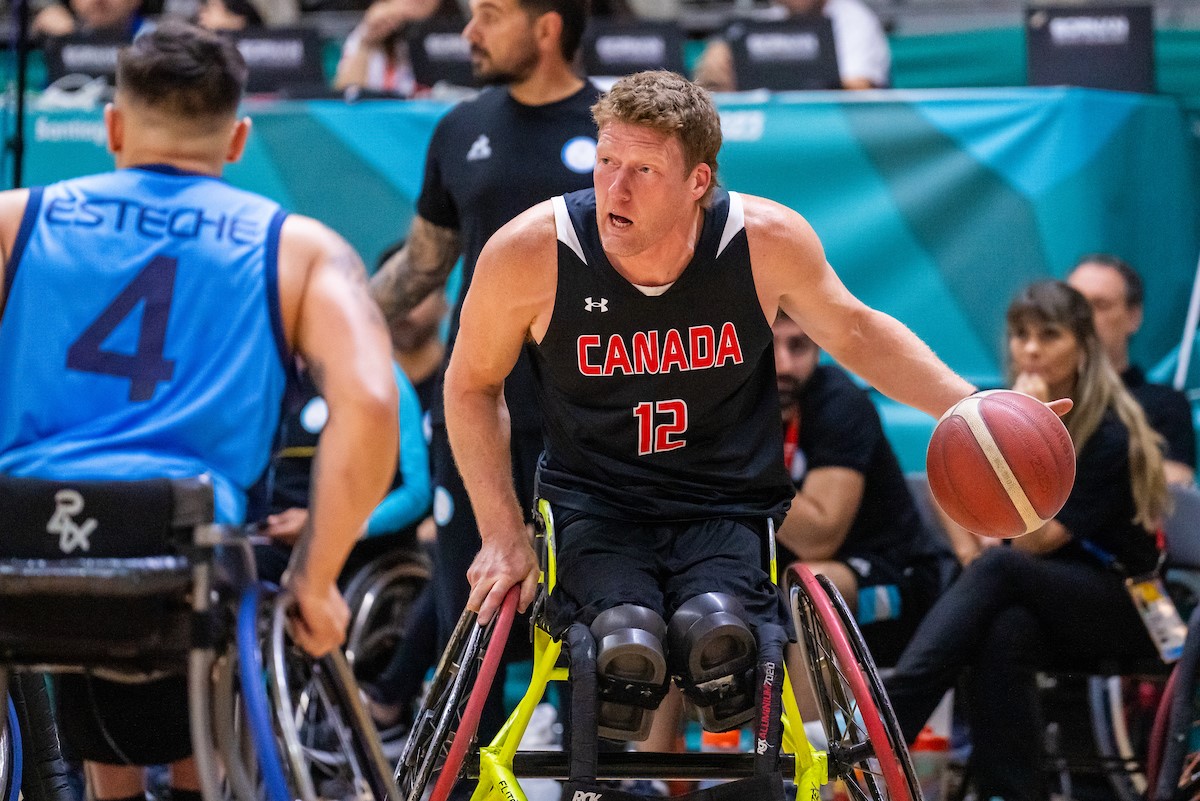 La star du basket-ball en fauteuil roulant Patrick Anderson fait rebondir le ballon.