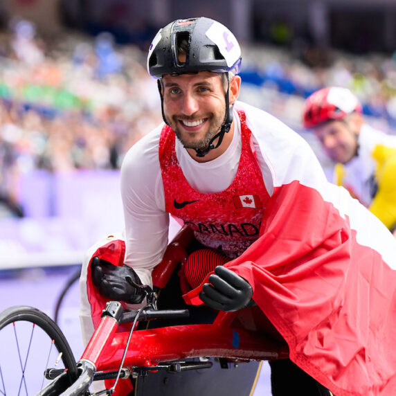 Cody Fournie dans son fauteuil roulant avec un drapeau Canadien