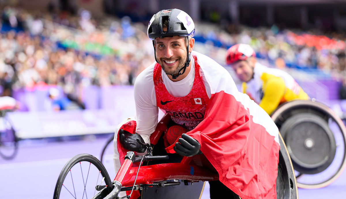 Cody Fournie dans son fauteuil roulant avec un drapeau Canadien