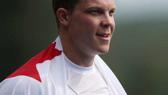 Image en portrait du rameur paralympique canadien Jeremy Hall avec le drapeau canadien drapé sur ses épaules.