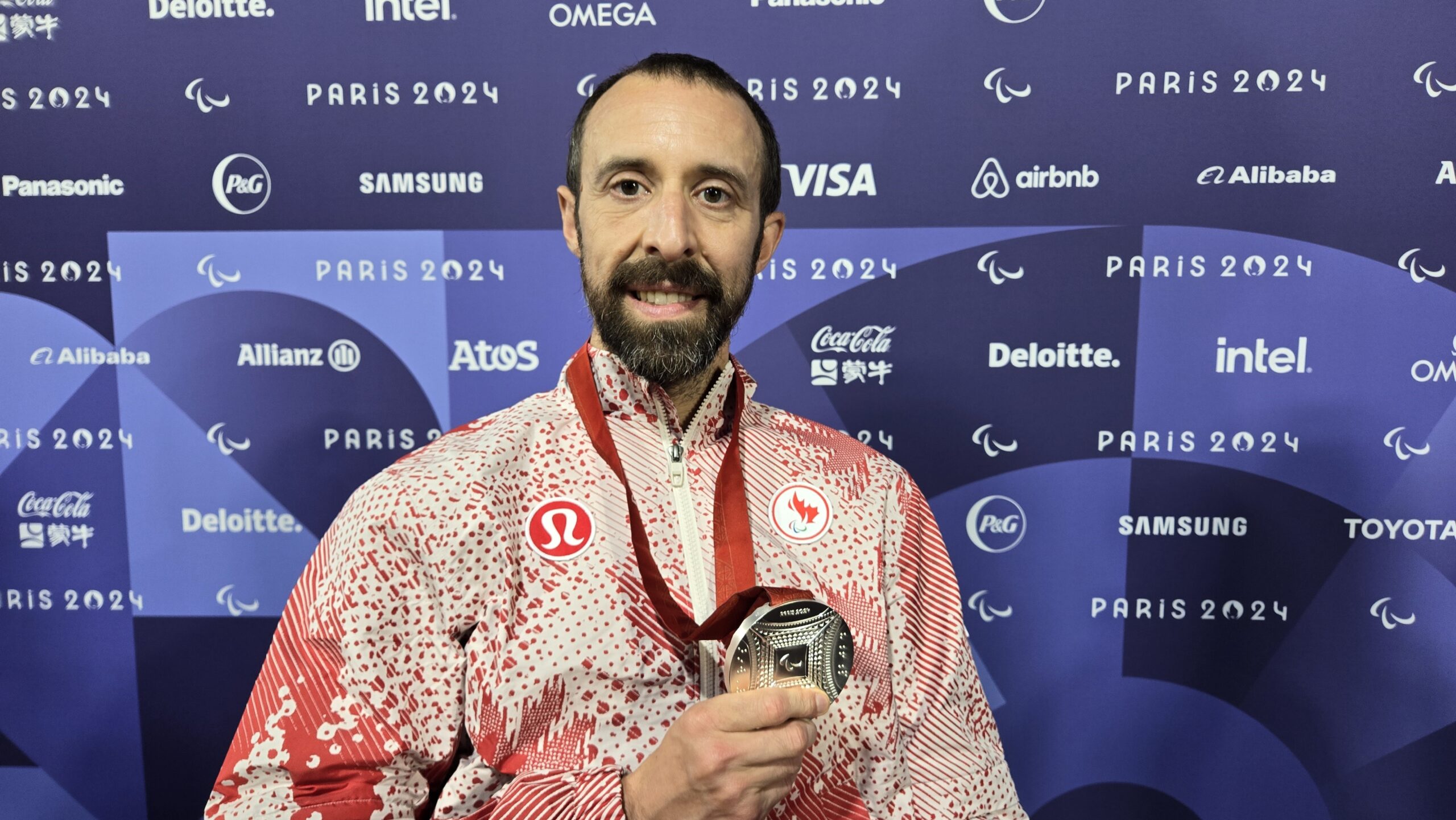 Brent Lakatos holding up his silver medal.