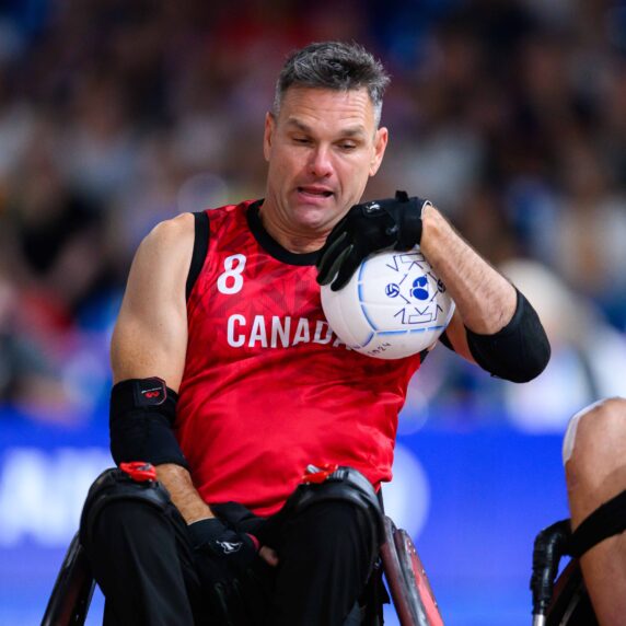 wheelchair basketball athlete carries the ball down the court