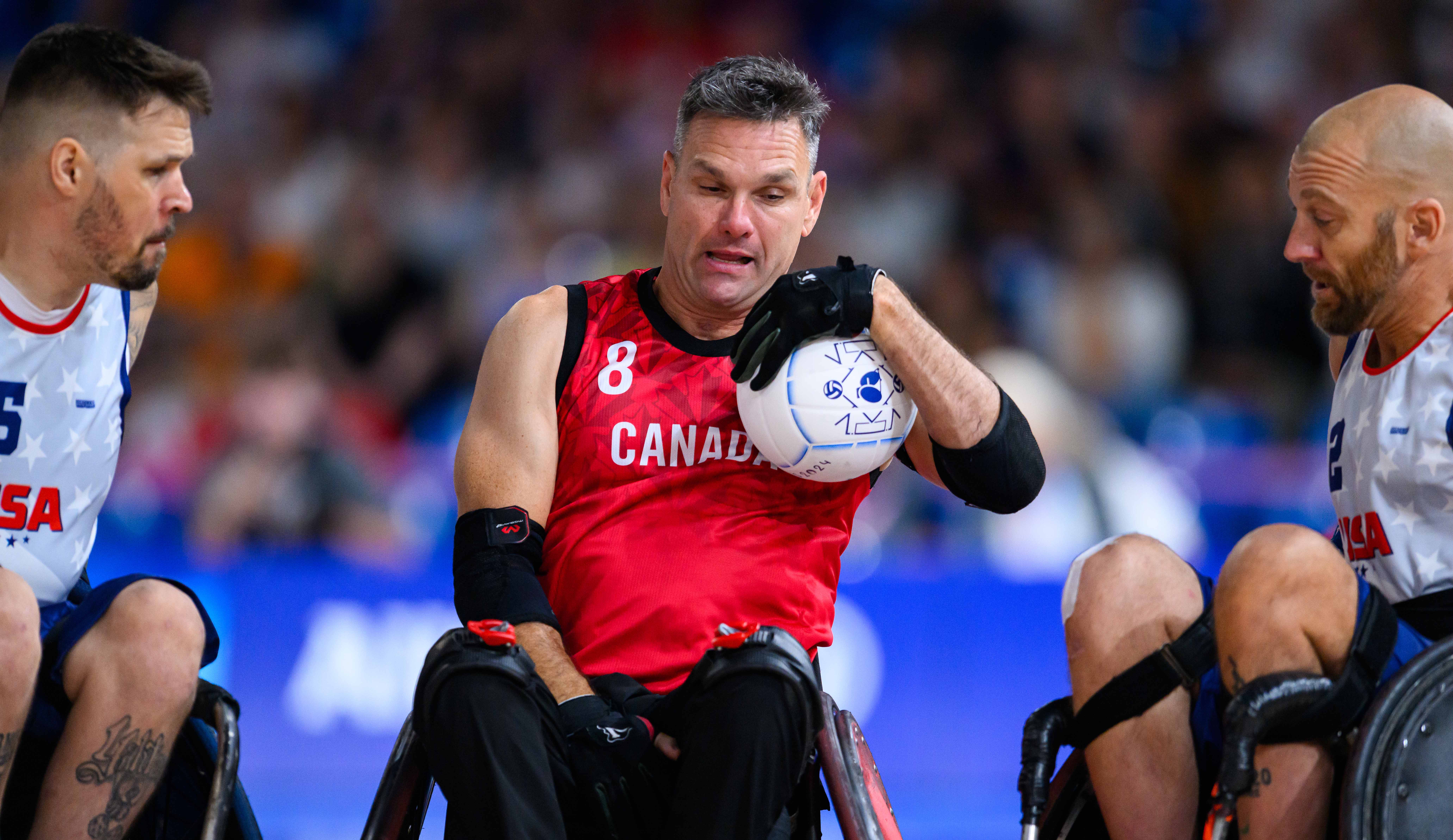 wheelchair basketball athlete carries the ball down the court