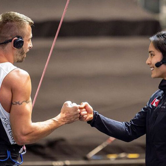 Le grimpeur canadien paralympique aveugle Chaz Misuraca donne un coup de poing à son guide Alannah Yip avant de commencer à grimper le mur.