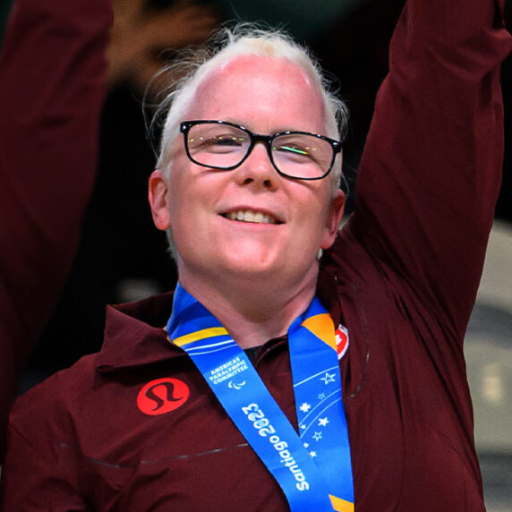 La joueuse canadienne de goalball Whitney Bogart célèbre sur le podium aux Jeux parapanaméricains de Santiago 2023 après avoir reçu sa médaille d’or aux côtés de ses coéquipières.