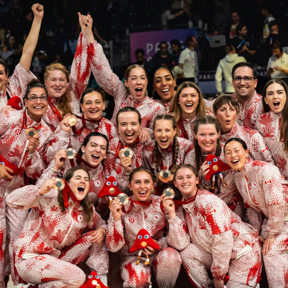 L’équipe féminine canadienne de volley-ball assis célèbre sa médaille de bronze aux Jeux paralympiques de Paris 2024. L’équipe pose ensemble dans ses uniformes à motifs rouges et blancs, souriant et tenant fièrement leurs médailles de bronze et les mascottes des Jeux paralympiques. Leur joie et leur unité reflètent cet accomplissement remarquable sur la scène mondiale.