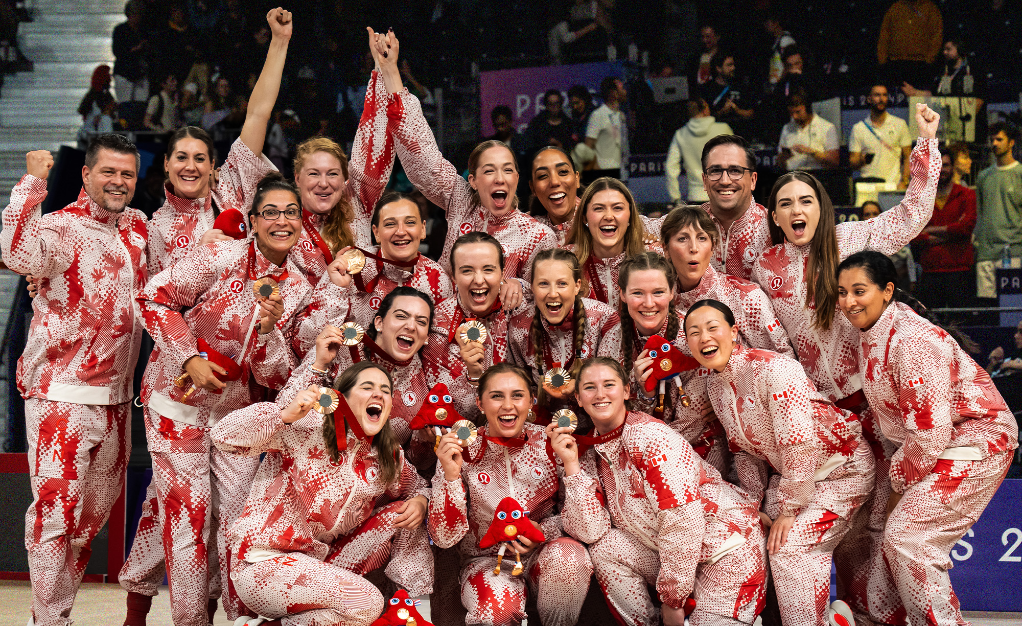 L’équipe féminine canadienne de volley-ball assis célèbre sa médaille de bronze aux Jeux paralympiques de Paris 2024. L’équipe pose ensemble dans ses uniformes à motifs rouges et blancs, souriant et tenant fièrement leurs médailles de bronze et les mascottes des Jeux paralympiques. Leur joie et leur unité reflètent cet accomplissement remarquable sur la scène mondiale.