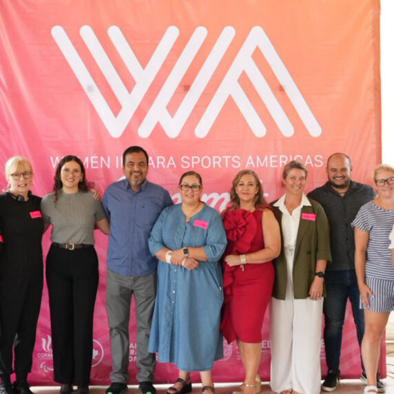 Photo de groupe des conférenciers et organisateurs devant une grande bannière rose et orange indiquant « Women in Para Sports Americas », lors du Sommet 2025 des femmes dans le sport paralympique des Amériques.