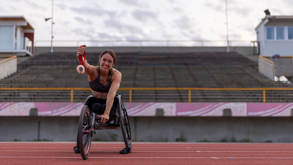 Leanne Taylor similing at the camera holding her medal